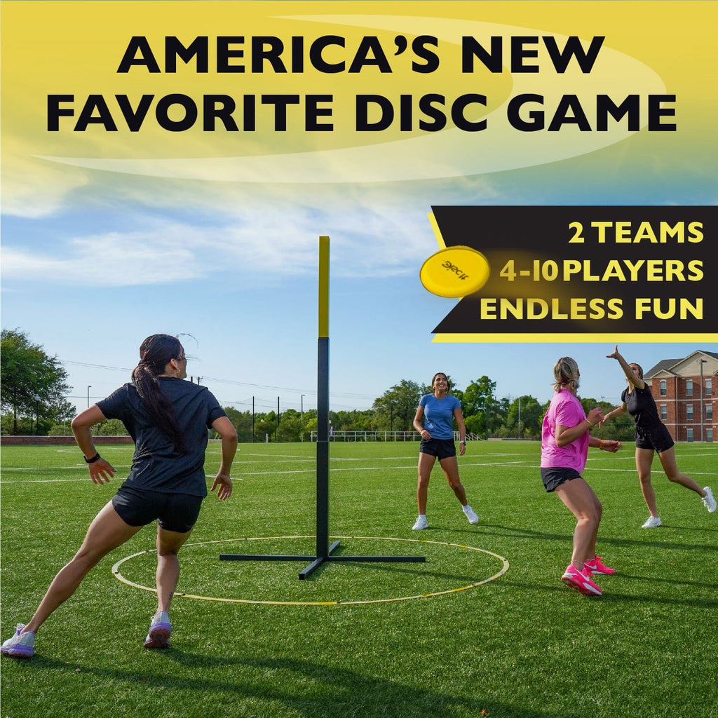 Group of young adults having fun playing Disc It in a grassy athletic field. 
